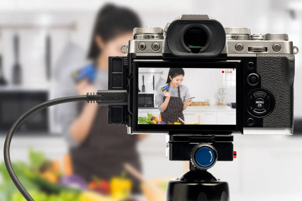 Blogger Asian women are beginning a home-based business to online teach cooking. Camera live streaming woman holding smartphone and credit card in monitor. Work from home. Blogger Asian women are beginning a home-based business to online teach cooking. Camera live streaming woman holding smartphone and credit card in monitor. Work from home. image based social media photos stock pictures, royalty-free photos & images
