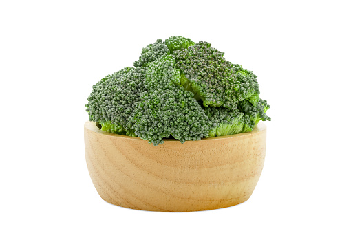 Fresh broccoli in a wooden bowl isolated on a white background.