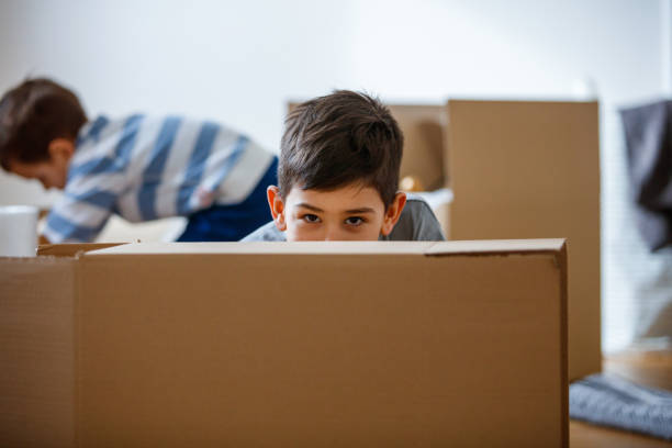 istock Boy behind the box looking at camera, family moving house 1282442620