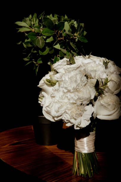 istock Wedding bouquet of white roses on a table in harsh light 1282442754