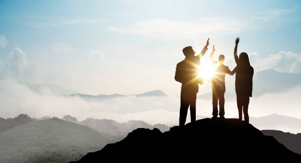 silhouette of business team zeigen arm auf dem gipfel des berges. führung und erfolg konzept. - high section stock-fotos und bilder