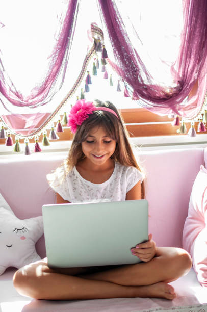 istock Littel girl using laptop at home 1282443748