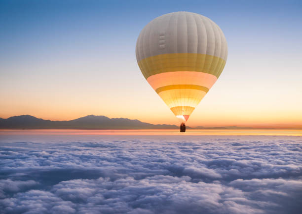 a lonely hot air balloon floats above the clouds. - hot air balloon landscape sunrise mountain imagens e fotografias de stock