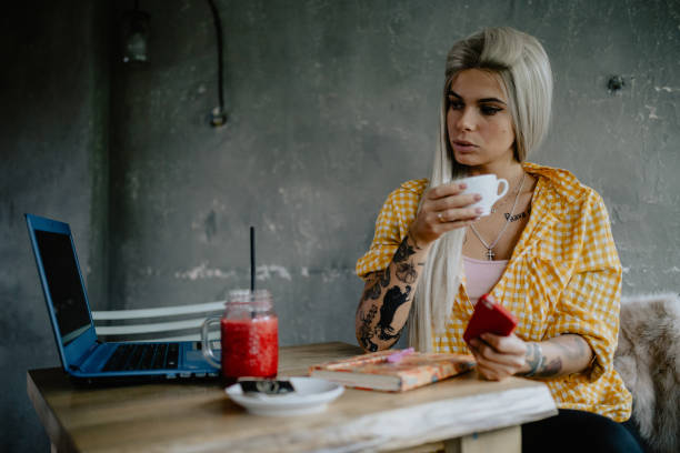 istock Tattooed woman dinking espresso and using a laptop in the bar 1282444909