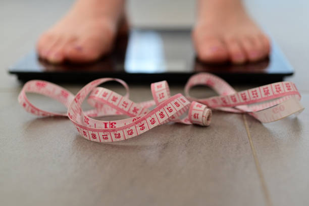 istock Woman measuring herself on a scale put weight 1282445044