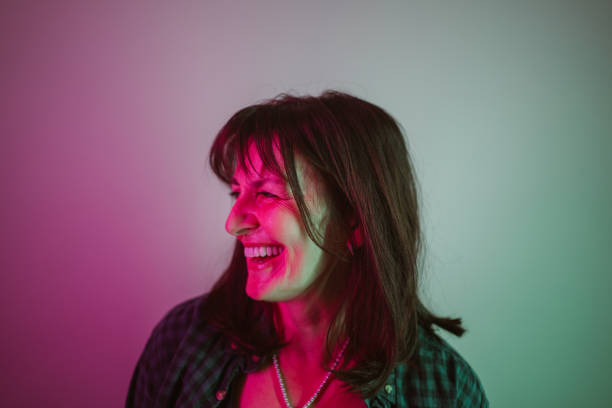 retrato de una mujer confiada bajo luces de neón - menopausia fotos fotografías e imágenes de stock