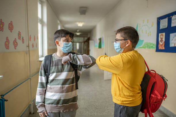 istock Two boys elbow bumping in school corridor 1282449222