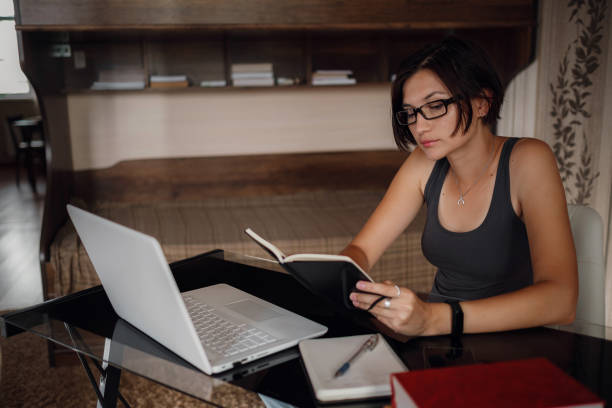istock Young female student in glasses using laptop, communicates on internet with teachers. 1282451732