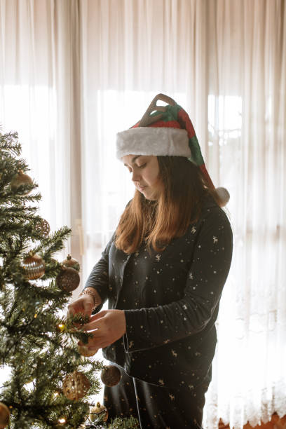 istock Young woman decorating a Christmas tree 1282452759