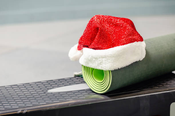 estera con sombrero de santa claus en el gimnasio - holiday healthy lifestyle weight christmas fotografías e imágenes de stock