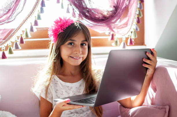 istock Littel girl using laptop at home 1282452949