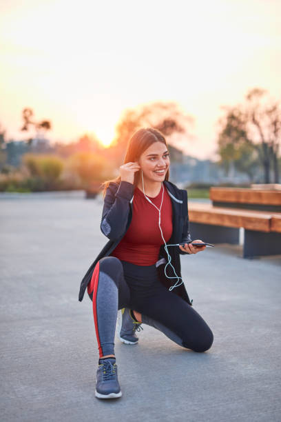 istock Modern young woman with cellphone making pause during jogging / exercise. 1282453115