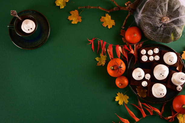 istock Halloween-themed concept: sugar ghosts, pumpkins, coffee on a dark green background. 1282454168