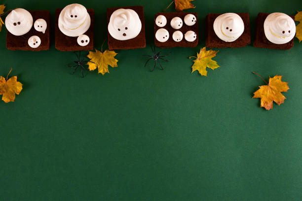 istock Halloween-themed concept: sugar ghosts, pumpkins, coffee on a dark green background. 1282454247