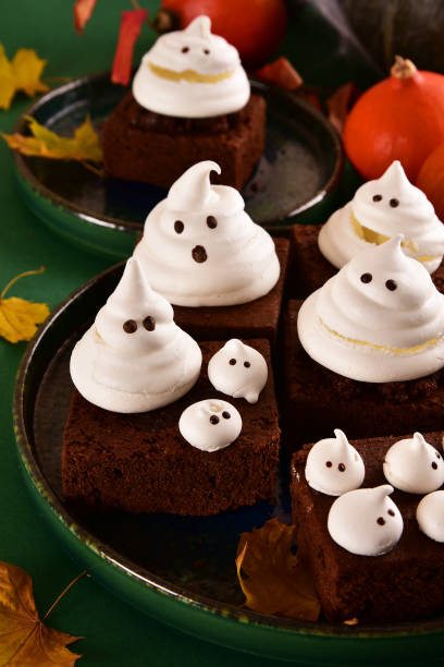 istock Halloween-themed concept: sugar ghosts, pumpkins, coffee on a dark green background. 1282454248