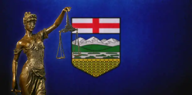 Photo of Lady Justice before a flag of Alberta