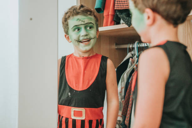garçon utilisant le maquillage pendant l’halloween - child playing dressing up imagination photos et images de collection