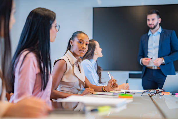 istock Young african woman sitting at a business presentation. 1282460892