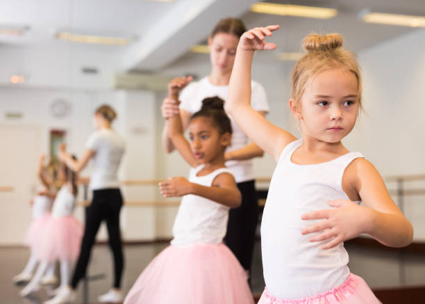 istock Dance teacher helping her little girls students 1282462476