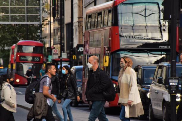 People wearing face masks on Oxford Street, London London, United Kingdom - October 7 2020: People wearing face masks on a crowded Oxford Street, daytime view covid crowd stock pictures, royalty-free photos & images
