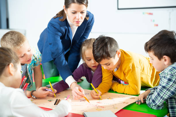 istock Kids and teacher playing educational board game 1282465271