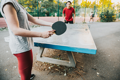 young friends playing table tennis single match in public sportspark in Berlin