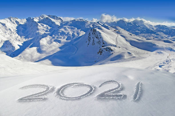 2021 written in the snow, mountain landscape in the background - new years party time imagens e fotografias de stock