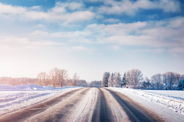 istock Winter road with snow and trees all around 1282466911