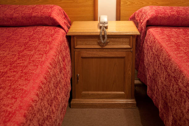 istock Phone on a night table in a cheap hotel room 1282466974