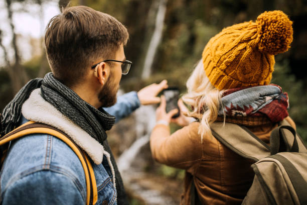 Capturing the moment A young couple taking a photo while hiking in the mountains hearing aid photos stock pictures, royalty-free photos & images