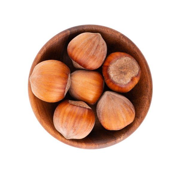 istock Hazelnut in wooden bowl, isolated on white background. Nut macro. With clipping path. Top view. 1282470524
