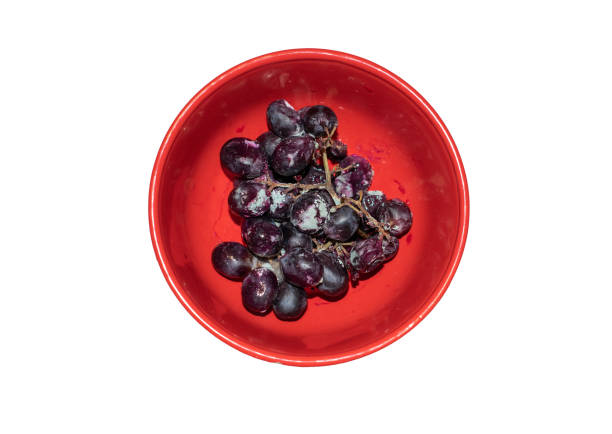 istock Missing grapes in a cup isolated on a white background. A bunch of grapes with mold. 1282472585