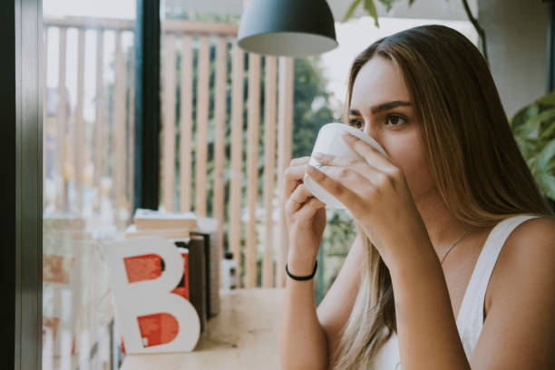 istock Beautiful woman is drinking coffee in cafe. 1282472657