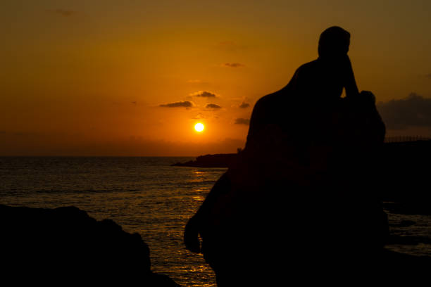 istock Sunset for the lady on the rock 1282472972
