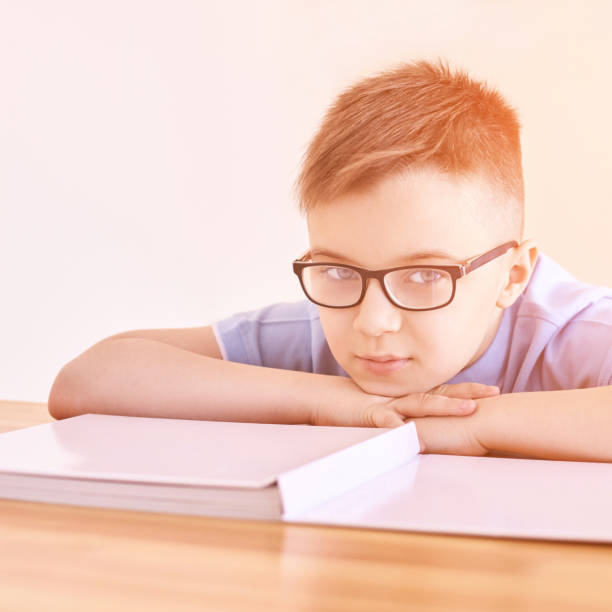 little boy in eyeglasses thinking at home. schoolboy study - eye exam child optometrist human eye imagens e fotografias de stock