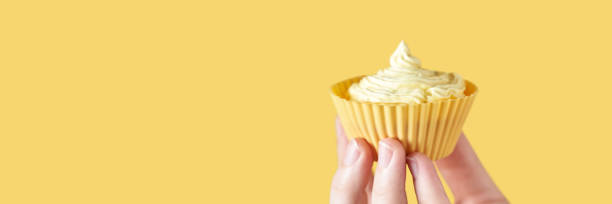 istock Yellow monochrome bakery. Sustainable cupcake cup. Hold in hand 1282478336