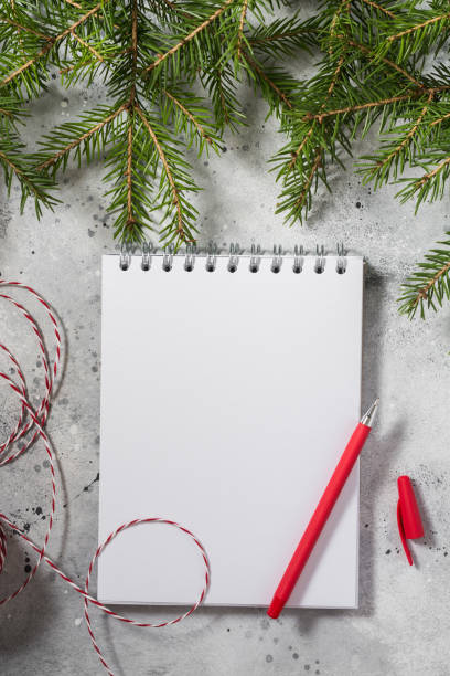 istock Christmas or New year holiday background with an open blank Notepad, fir branches and traditional Christmas decorations. A checklist or a letter to Santa. Christmas business greeting card. Copyspace 1282478818