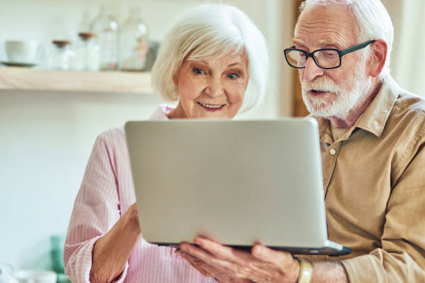 istock Senior man and woman using laptop together 1282480438