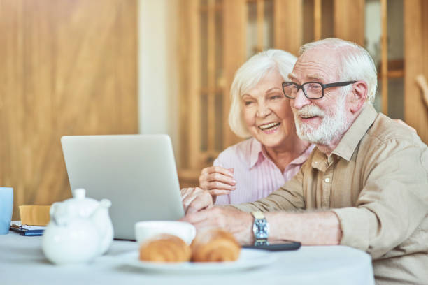 istock Smiling elderly couple watching funny video on computer 1282481259