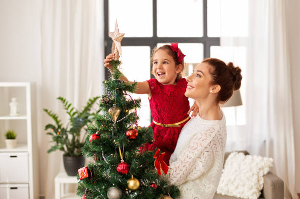 istock happy family decorating christmas tree at home 1282481652