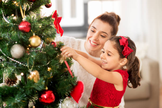 istock happy family decorating christmas tree at home 1282481662