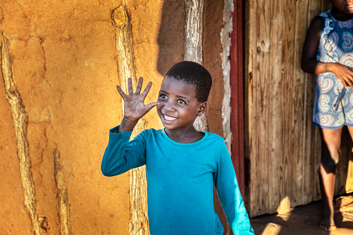 hello world happy African child waving and greeting the guests in her village in Botswana