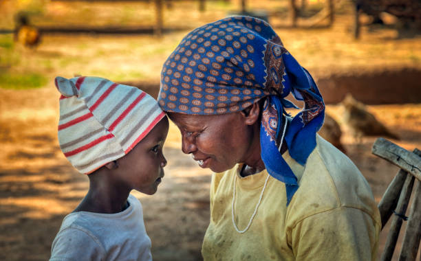 abuelita africana junto con su nieta - africa child village smiling fotografías e imágenes de stock