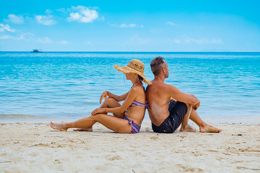 Cuople sitting at tropical beach