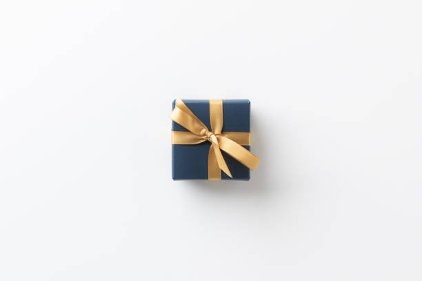 istock Top view blue present gift box with gold ribbon on the white table background. Merry christmas and Happy new year theme. 1282484783
