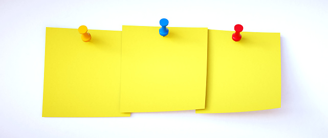 Three yellow blank sticky notes pinned to a white background. Suitable for additional composition.