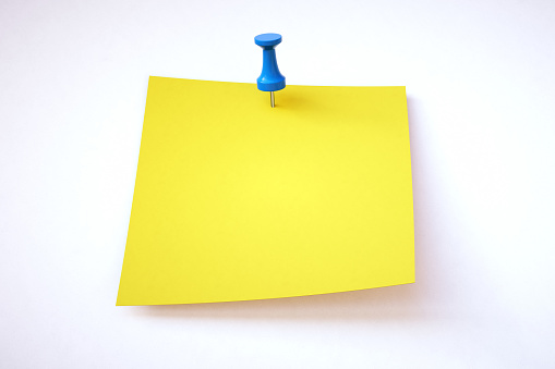 Single yellow empty sticky note pinned to a white background. Suitable for additional composition.