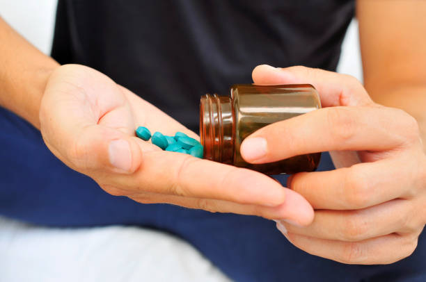istock young man with a bottle of pills 1282485685