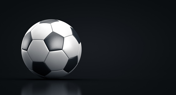 Soccer ball in a dark room. Copy space