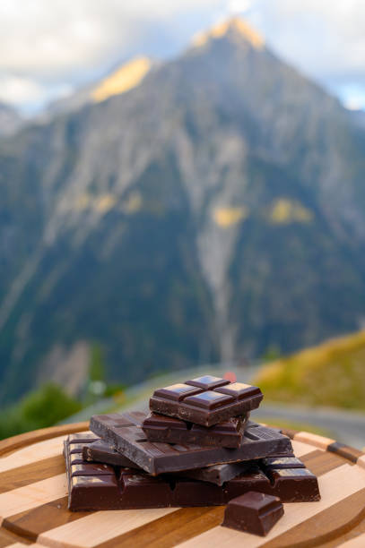 istock Handmade pure dark swiss chocolate and Alpine mountains on background 1282487410